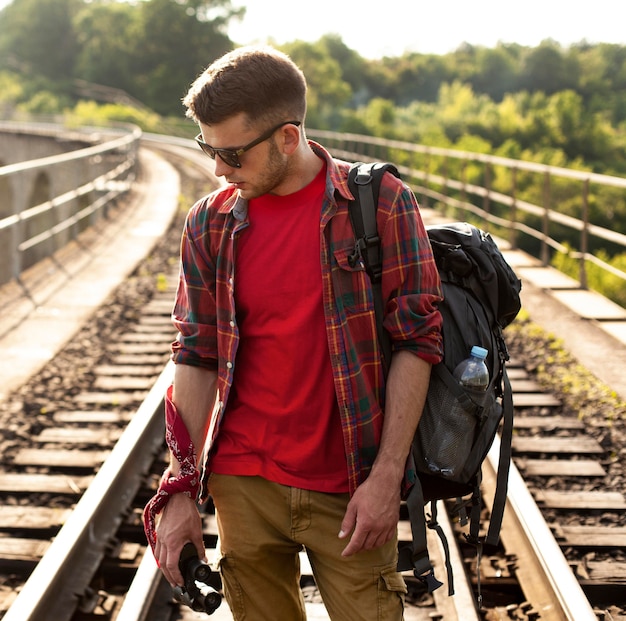 Foto gratuita hombre con mochila en riel de tren