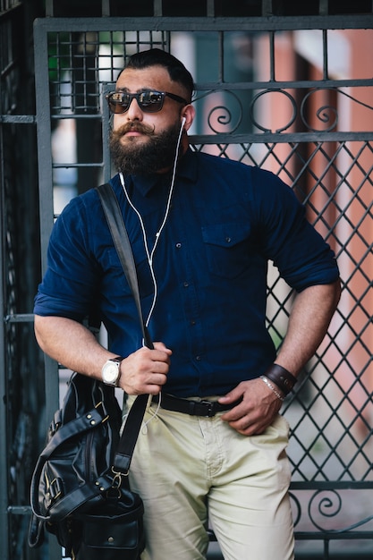 Hombre a la moda tocando su cinturón