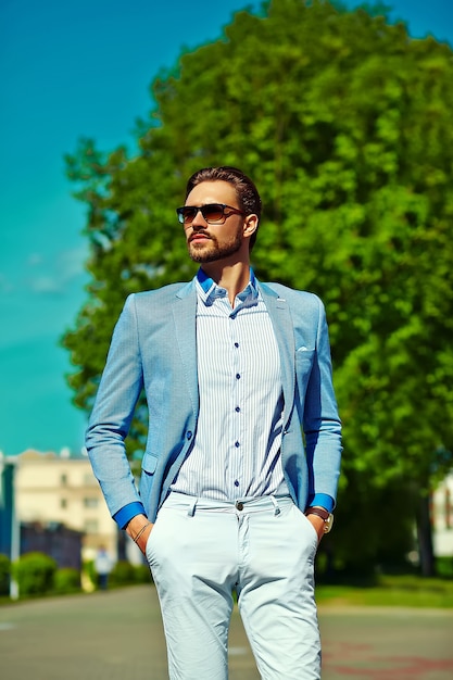 Foto gratuita hombre modelo empresario en traje azul estilo de vida de tela en la calle con gafas de sol