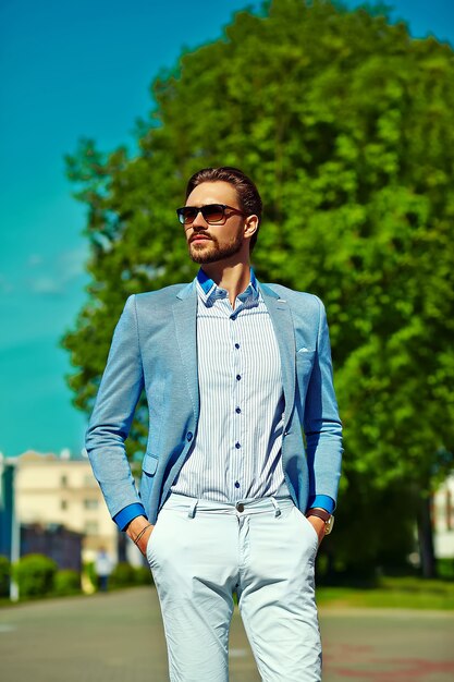 hombre modelo empresario en traje azul estilo de vida de tela en la calle con gafas de sol