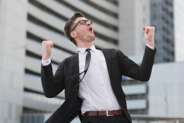 Hombre moderno de ángulo bajo feliz