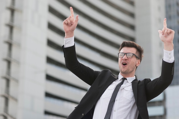 Hombre moderno de ángulo bajo señalando