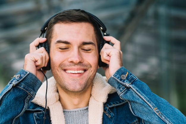 Foto gratuita hombre moderno con auriculares en entorno urbano