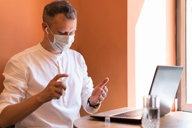 Hombre moderno con desinfectante en su trabajo