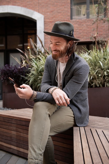 Foto gratuita hombre moderno escuchando música en su teléfono