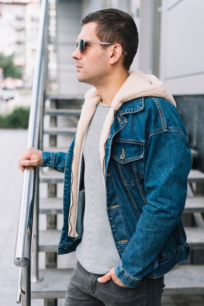 Hombre moderno con gafas de sol en ciudad