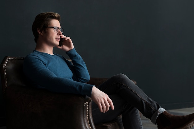 Hombre moderno de lado hablando por teléfono