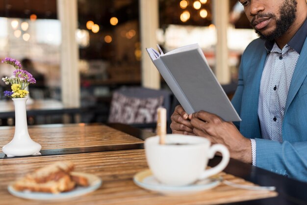 Hombre moderno leyendo en una mesa con espacio de copia