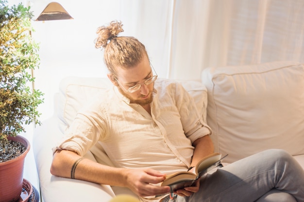 Foto gratuita hombre moderno leyendo en sofá