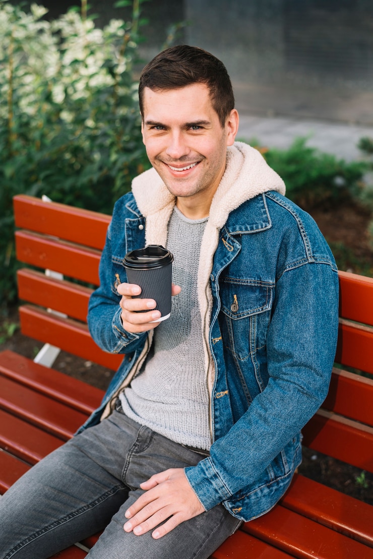 Foto gratuito hombre moderno sentado en banco en entorno urbano