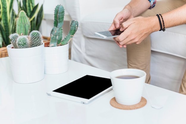 Hombre moderno con smartphone en sofá