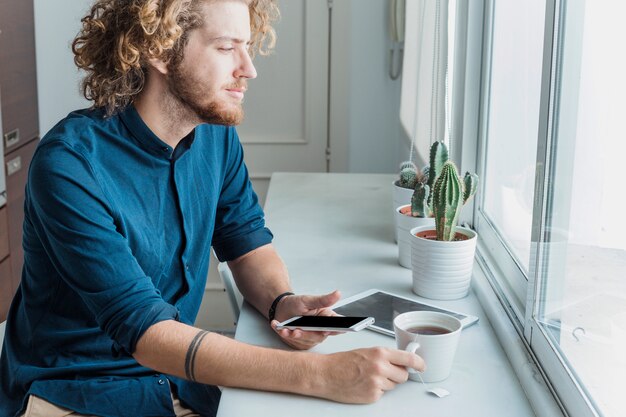 Foto gratuita hombre moderno con smartphone y tableta