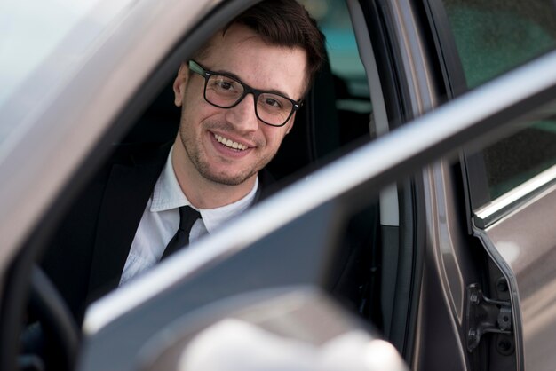 Hombre moderno sonriente en coche