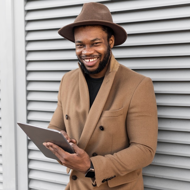 Hombre moderno sonriente sosteniendo una tableta