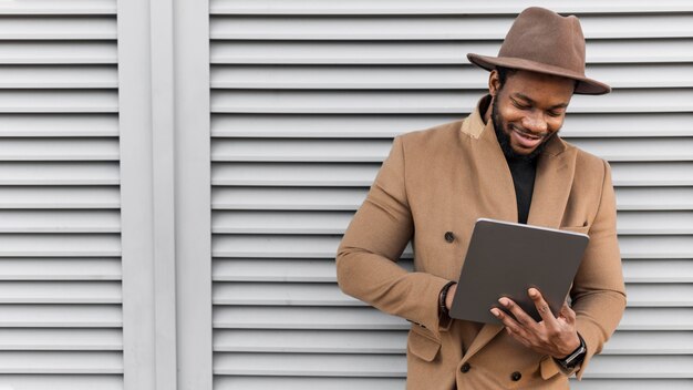 Hombre moderno sonriente en su tableta