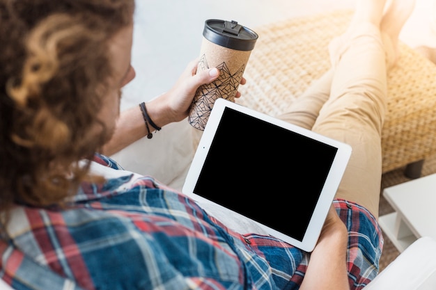 Foto gratuita hombre moderno con tableta en sofá