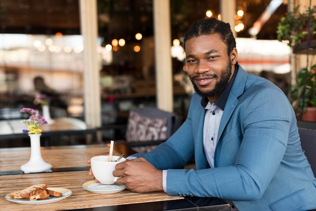 Hombre moderno tomando su café en un restaurante