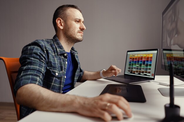 Foto gratuita hombre moderno trabajando remotamente en una computadora desde la oficina en casa