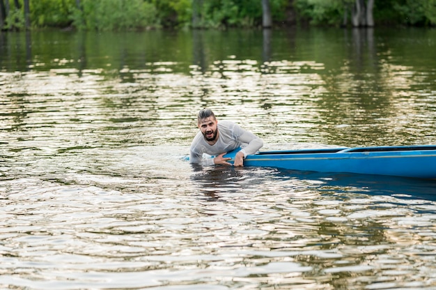 Hombre mojado con canoa