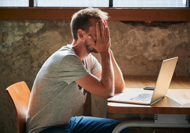 Foto gratuita hombre molesto con las manos en la cara atormentado por el trabajo