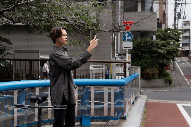 Hombre montando bicicleta en la ciudad y tomando selfie con smartphone