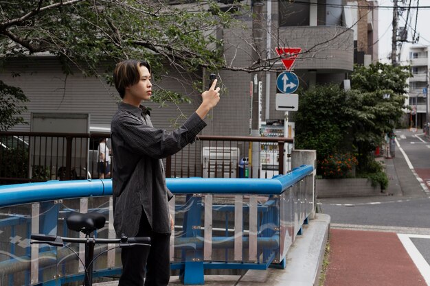 Hombre montando bicicleta en la ciudad y tomando selfie con smartphone