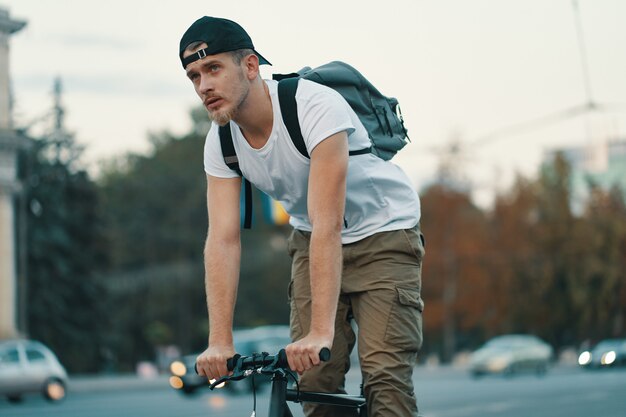 Hombre montando bicicleta en la ciudad urbana de la mano en el manillar