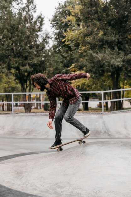 Hombre montando patineta al aire libre