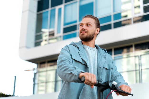 Foto gratuita hombre montando un scooter al aire libre