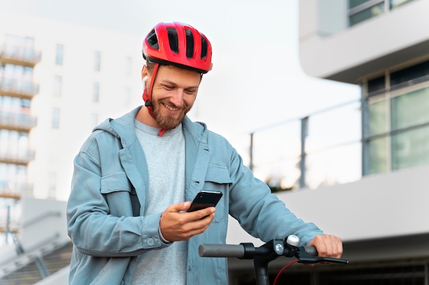 Hombre montando un scooter ecológico en la ciudad.