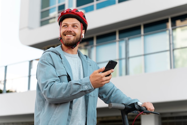 Hombre montando un scooter ecológico en la ciudad.