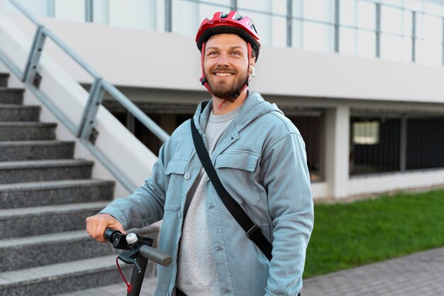 Hombre montando un scooter ecológico en la ciudad.