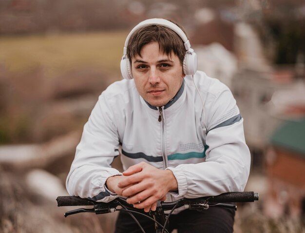 Hombre montando su bicicleta mientras escucha música con auriculares