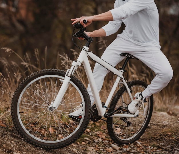 Hombre montando su bicicleta en ropa blanca