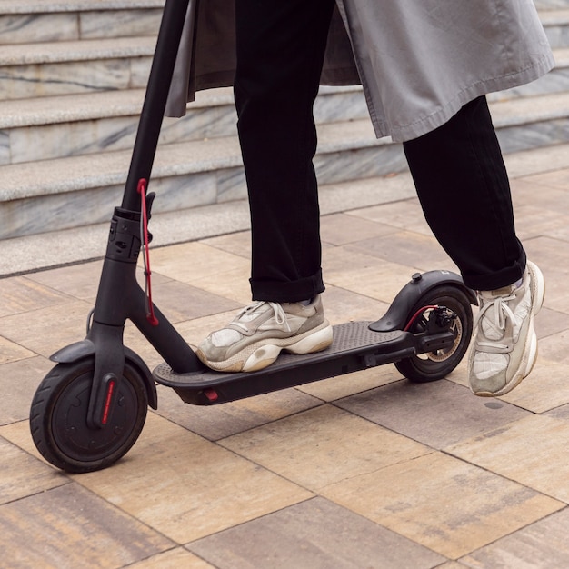 Hombre montando su scooter eléctrico en la ciudad