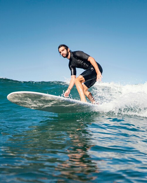 Hombre montando su tabla de surf y pasando un buen rato