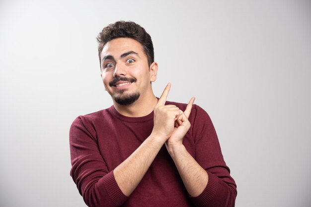 Un hombre morena feliz posando con las manos.