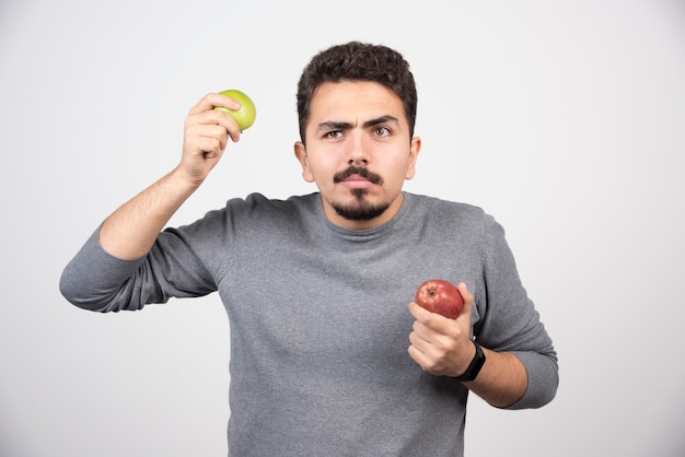 Hombre morena con manzanas en gris.