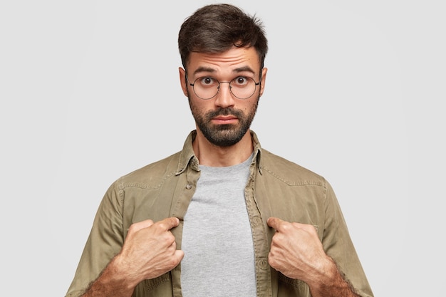 Hombre moreno vestido con anteojos redondos y camisa beige