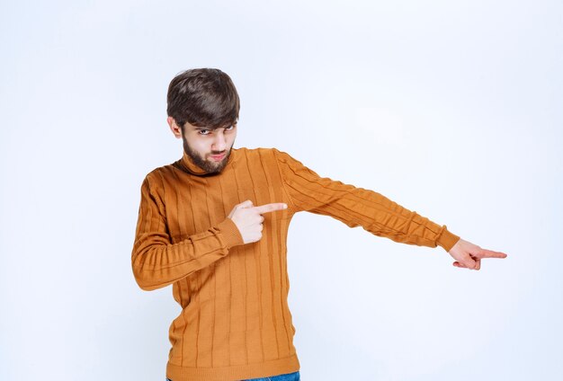 Hombre mostrando algo en el lado derecho.