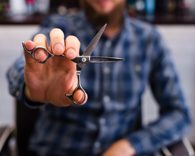 Foto gratuita hombre mostrando primer plano de tijeras