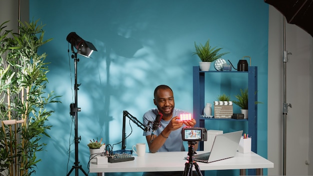 Hombre mostrando el producto en la cámara y filmando vlog