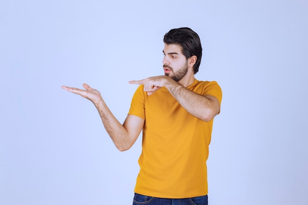 Hombre mostrando y señalando el lado izquierdo.