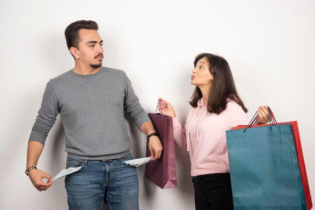 Hombre mostrando su bolsillo por no tener dinero a su amante.