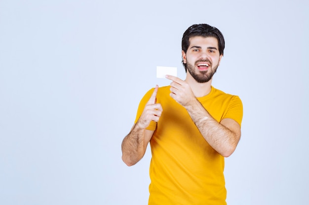 Hombre mostrando su tarjeta de visita y presentándose con confianza.