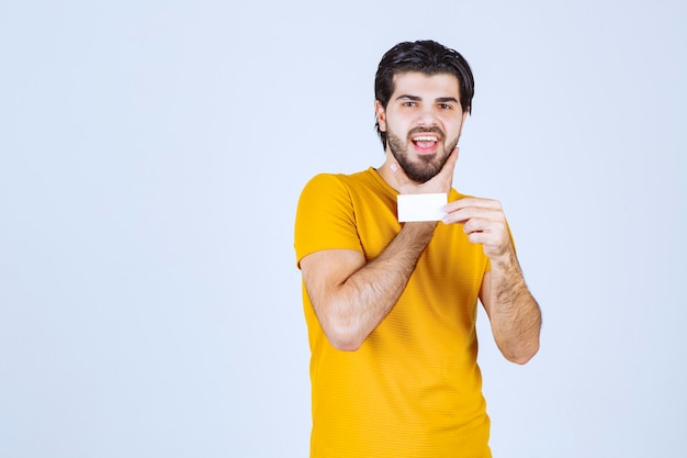 Hombre mostrando su tarjeta de visita y presentándose con confianza.