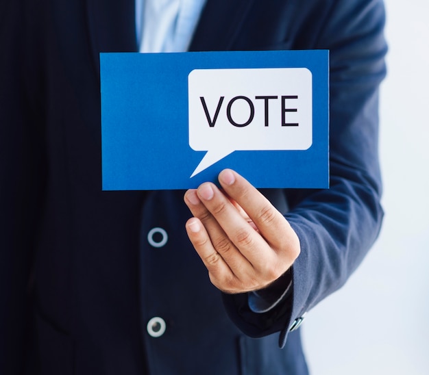 Hombre mostrando una tarjeta de votación con un bocadillo