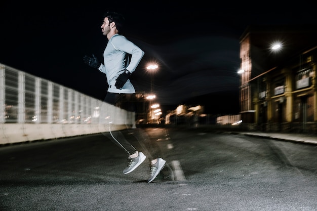 Hombre en movimiento de correr en la oscuridad