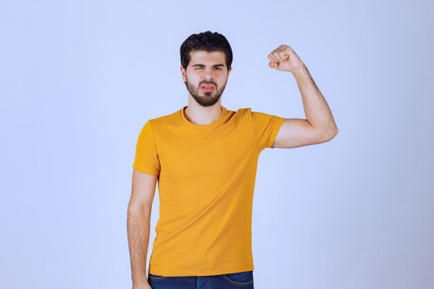 El hombre muestra los músculos del brazo y se siente poderoso.