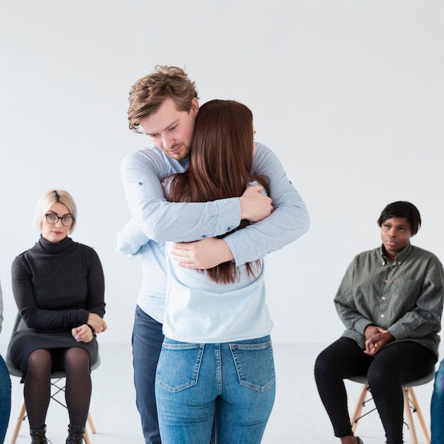 Hombre y mujer abrazados en una clínica de rehabilitación